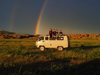 The kids in The Movie Blink sitting on a van framed by a sunset