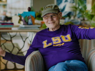 James Carville waiving hello wearing LSU sweatshirt. Movie Winning Is Everything Stupid
